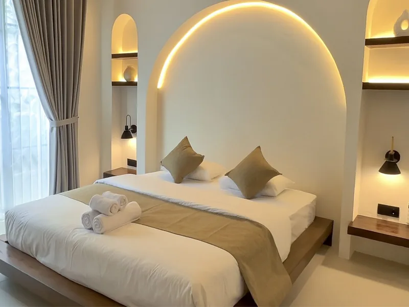 Malasama Villas: dormitorio con cabecero en arco iluminado